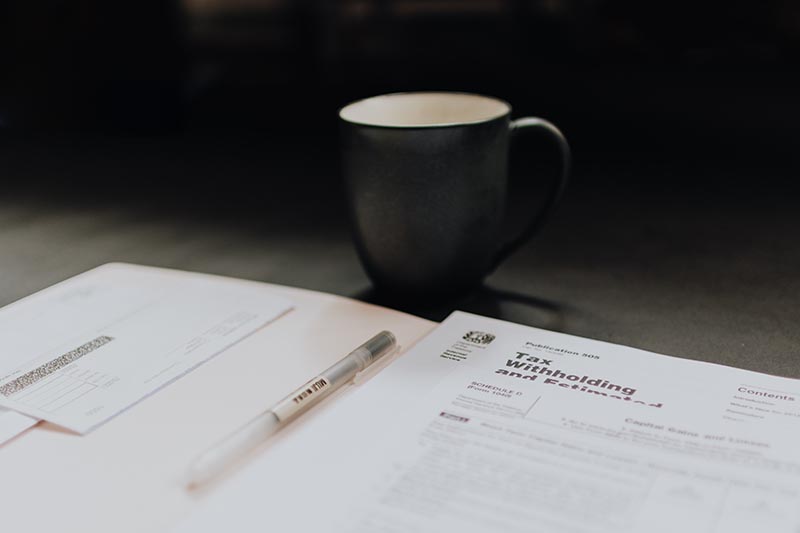 A photo of tax papers beside a coffee mug.